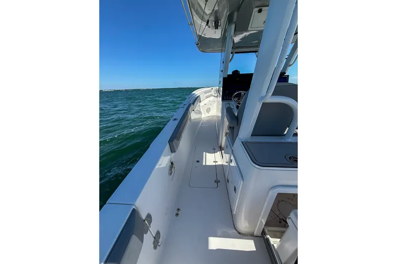 Slide: The Image of 2023 Sea Pro 320 DLX Offshore boat on open water, showcasing sleek design and spacious deck. - 28