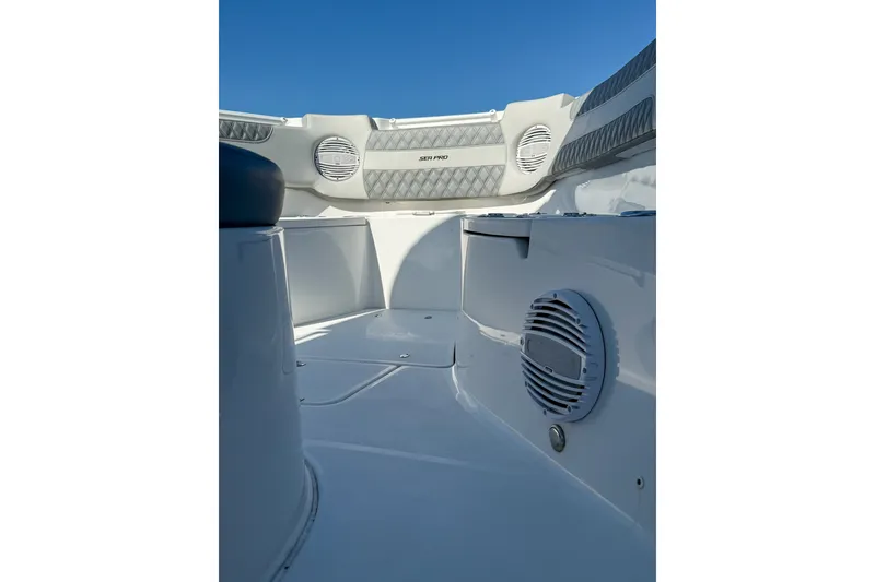 Slide: The Image of 2023 Sea Pro 320 DLX Offshore boat interior with speakers and seating, under clear blue sky. - 19
