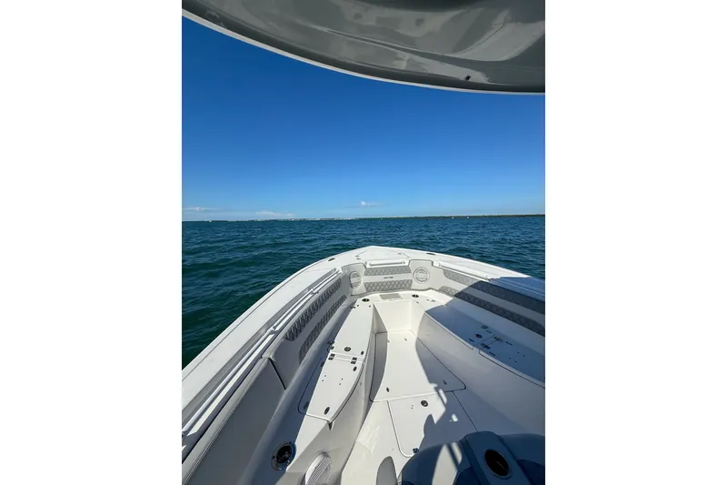 Slide: The Image of 2023 Sea Pro 320 DLX Offshore boat on open water under clear blue sky. - 14