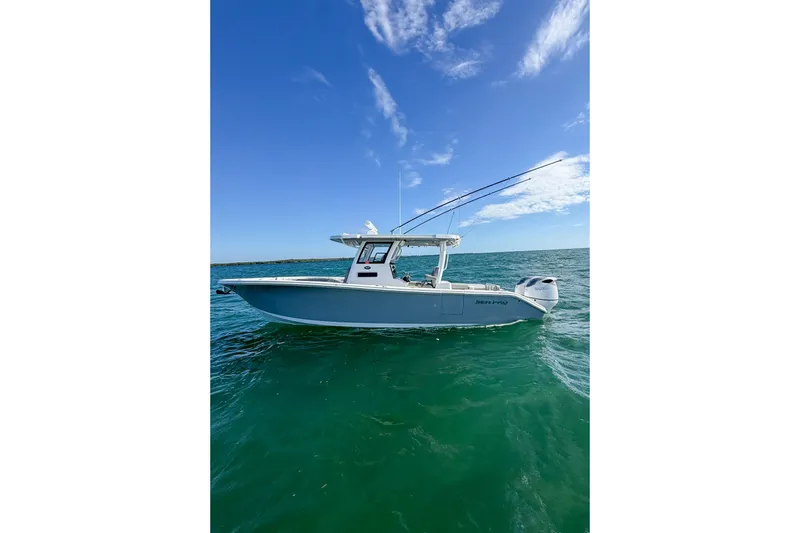 Slide: The Image of 2023 Sea Pro 320 DLX Offshore boat on clear blue ocean under a bright sky. - 11