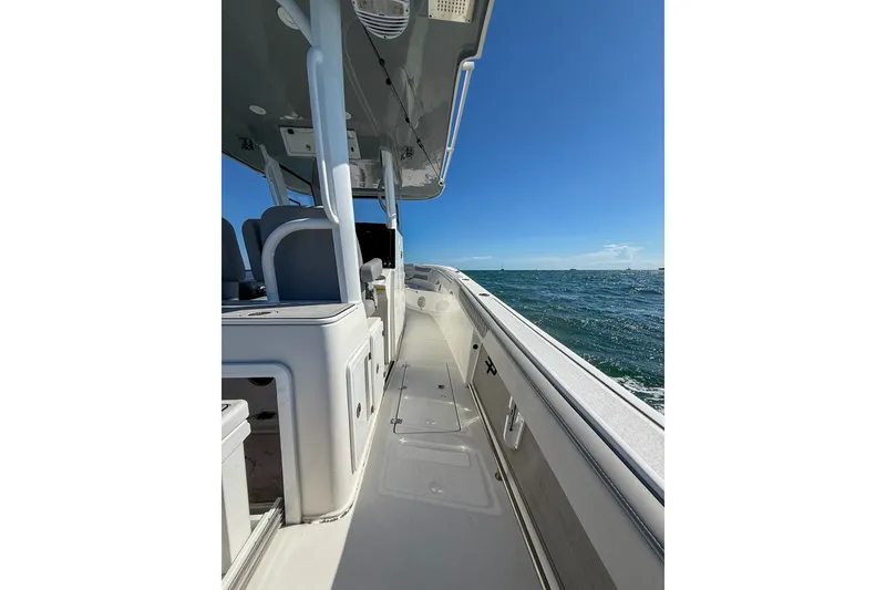 Slide: The Image of 2023 Sea Pro 320 DLX Offshore boat on open water, showcasing sleek design and spacious deck. - 29