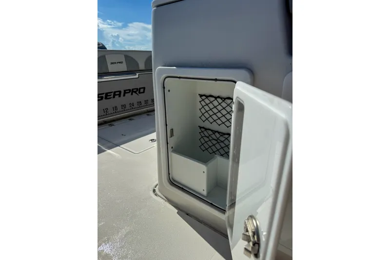 Slide: The Image of Open storage compartment on 2023 Sea Pro 320 DLX Offshore boat, featuring netted interior. - 24