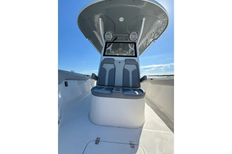 Slide: The Image of 2023 Sea Pro 320 DLX Offshore boat interior with cushioned seating and overhead canopy. - 18