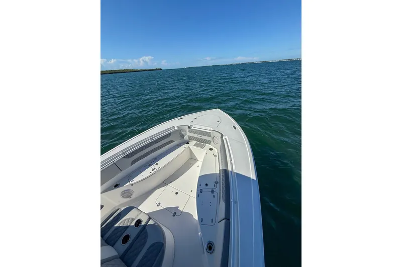 Slide: The Image of 2023 Sea Pro 320 DLX Offshore boat on open water under clear blue sky. - 17