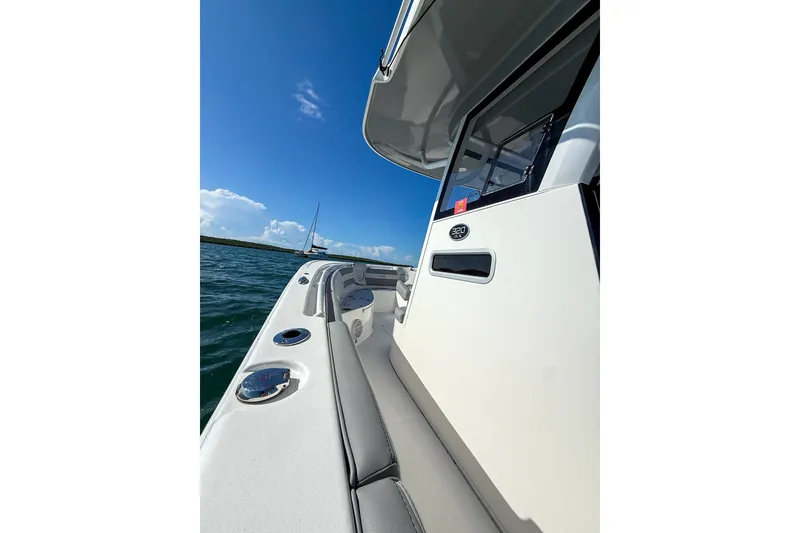 Slide: The Image of 2023 Sea Pro 320 DLX Offshore boat on water, showcasing sleek design and spacious deck. - 13