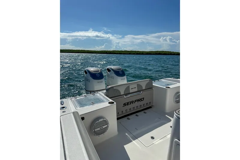 Slide: The Image of 2023 Sea Pro 320 DLX Offshore boat on water, featuring dual Suzuki engines. - 23