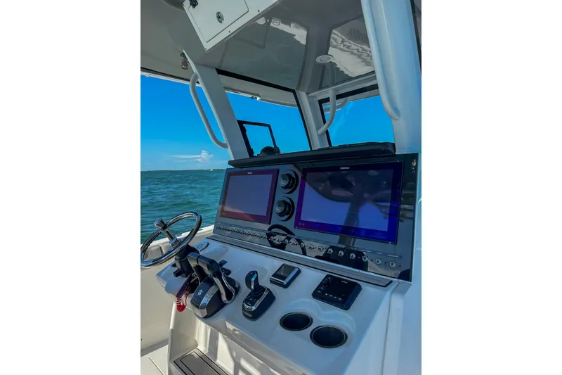 Slide: The Image of 2023 Sea Pro 320 DLX Offshore boat dashboard with dual screens and steering wheel. - 21