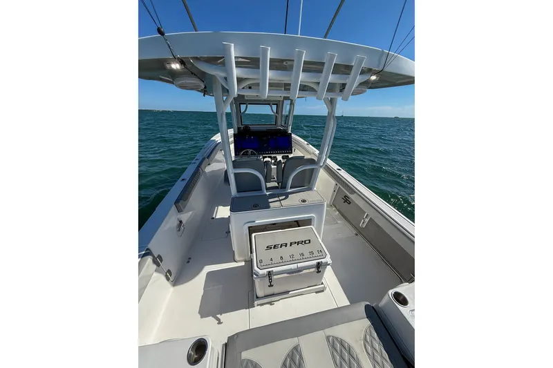 Slide: The Image of 2023 Sea Pro 320 DLX Offshore boat on open water, showcasing spacious deck and seating. - 27