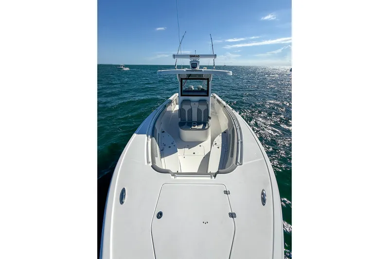 Slide: The Image of 2023 Sea Pro 320 DLX Offshore boat cruising on open water under clear skies. - 15