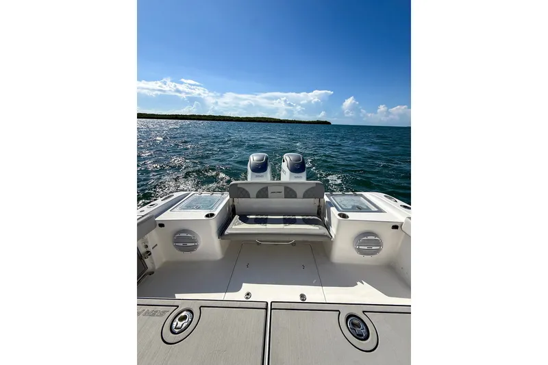 Slide: The Image of 2023 Sea Pro 320 DLX Offshore boat on open water under clear blue sky. - 26