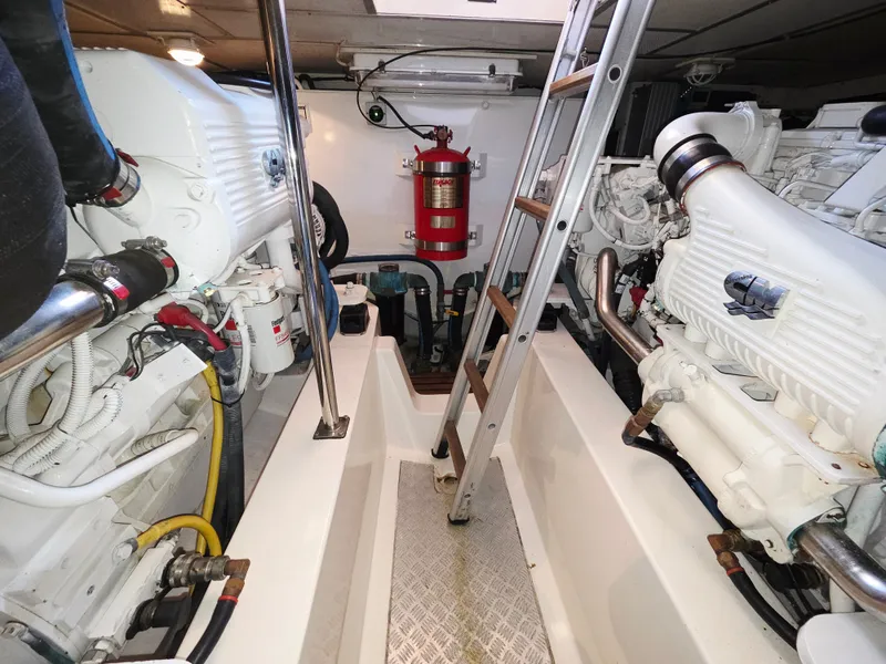 Slide: The Image of Engine room of a 2010 Grand Banks SX with two large engines and a ladder. - 36