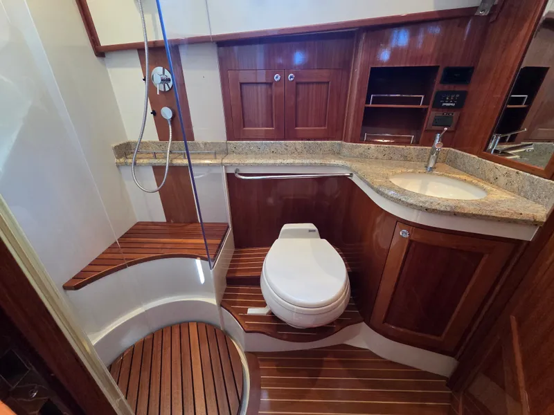 Slide: The Image of The image shows an elegant bathroom on a 2010 Grand Banks SX yacht with wood accents and granite surfaces. - 29