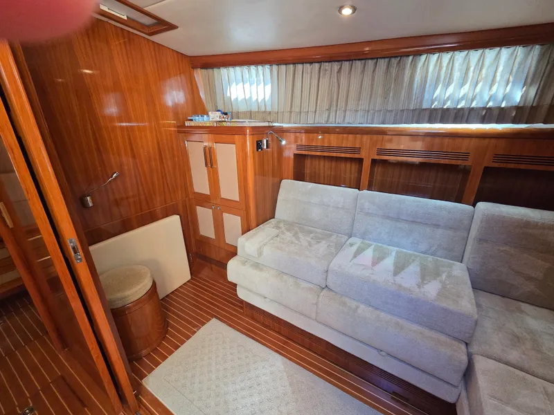 Slide: The Image of Interior of a 2010 Grand Banks SX with wooden walls and beige sofa. - 28