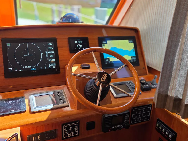 Slide: The Image of Helm of the 2010 Grand Banks SX with wooden wheel and modern navigation instruments. - 17