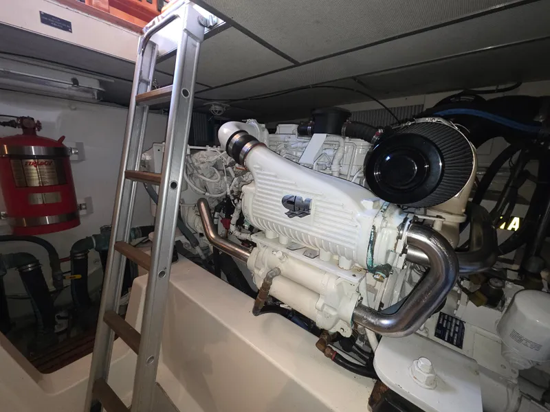 Slide: The Image of An engine room with a large engine, a ladder, and a fire extinguisher on the wall. - 38