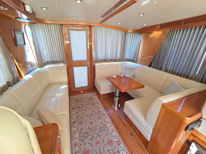 Slide: The Image of Interior of a 2010 Grand Banks SX with elegant wood accents and comfortable leather sofas. - 21