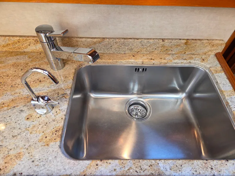 Slide: The Image of Stainless steel sink with modern faucet on a granite countertop in a boat's galley. - 35