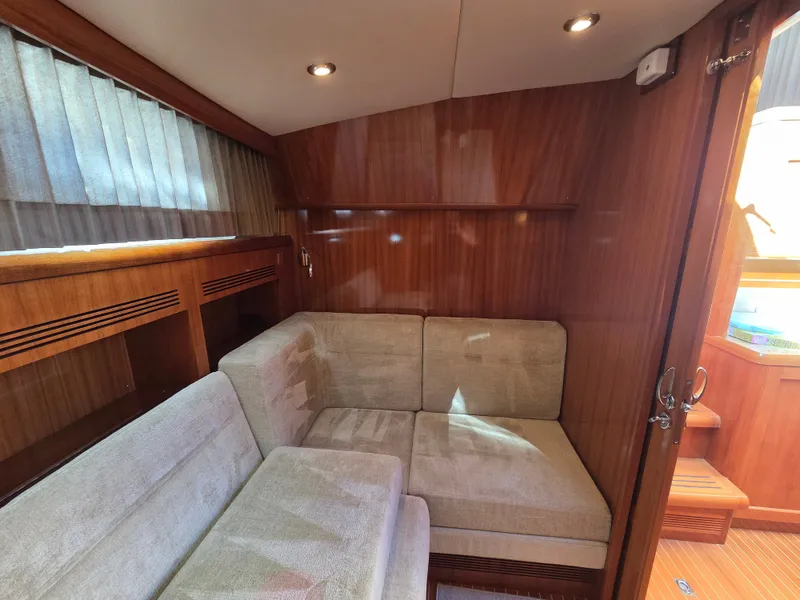 Slide: The Image of Cozy salon area with beige upholstery and wooden walls on a 2010 Grand Banks SX. - 32