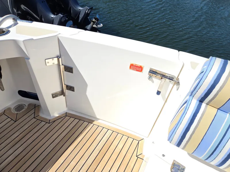 Slide: The Image of The image shows the deck of a 2010 Grand Banks SX with striped upholstery. - 14