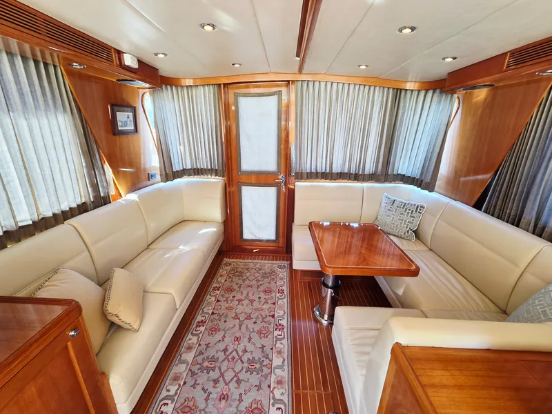 Slide: The Image of Interior of a 2010 Grand Banks SX with elegant wood accents and comfortable white sofas. - 20