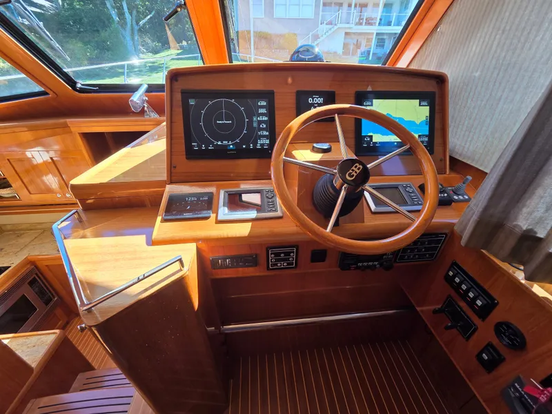 Slide: The Image of The cockpit of a 2010 Grand Banks SX with wood paneling and modern navigation instruments. - 18