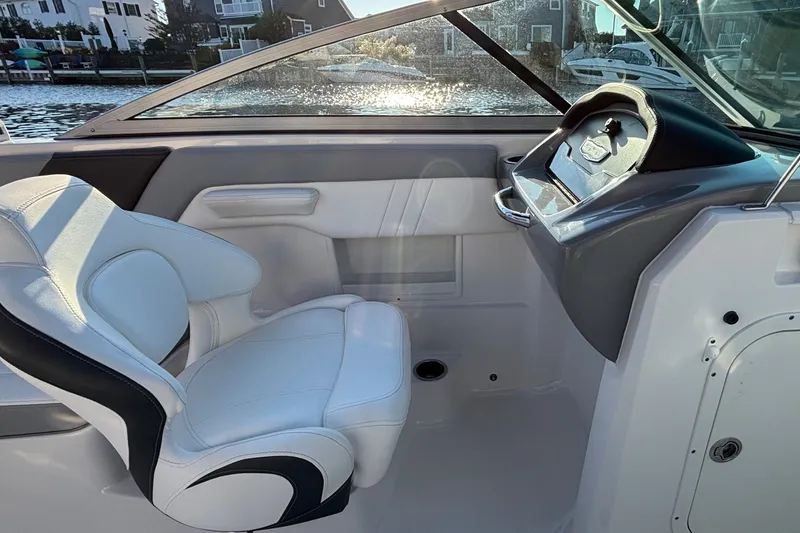 Slide: The Image of 2022 Chaparral 23 SSi OB boat interior with white seating and steering console. - 16