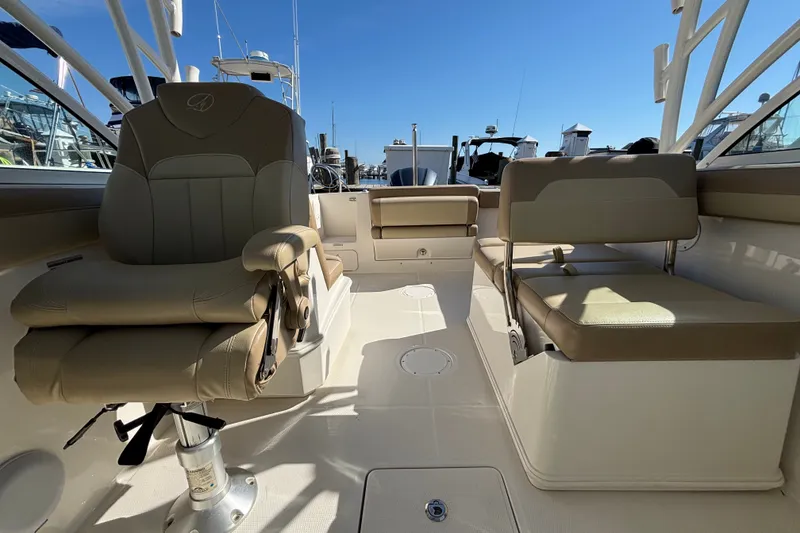 Slide: The Image of Interior view of a 2018 Sailfish 245 DC boat with beige seating and clear blue sky. - 18