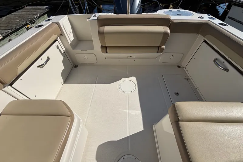 Slide: The Image of Spacious interior of 2018 Sailfish 245 DC boat with beige seating and storage compartments. - 21