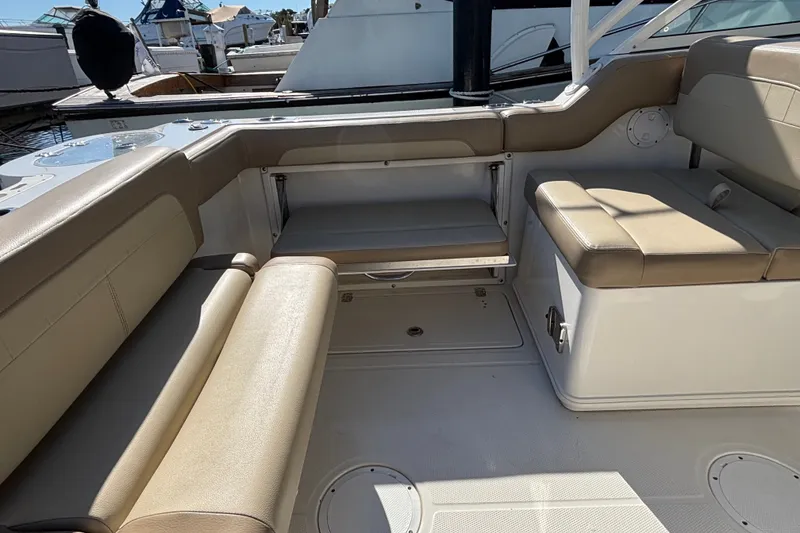 Slide: The Image of 2018 Sailfish 245 DC boat interior with beige seating and storage compartments. - 23