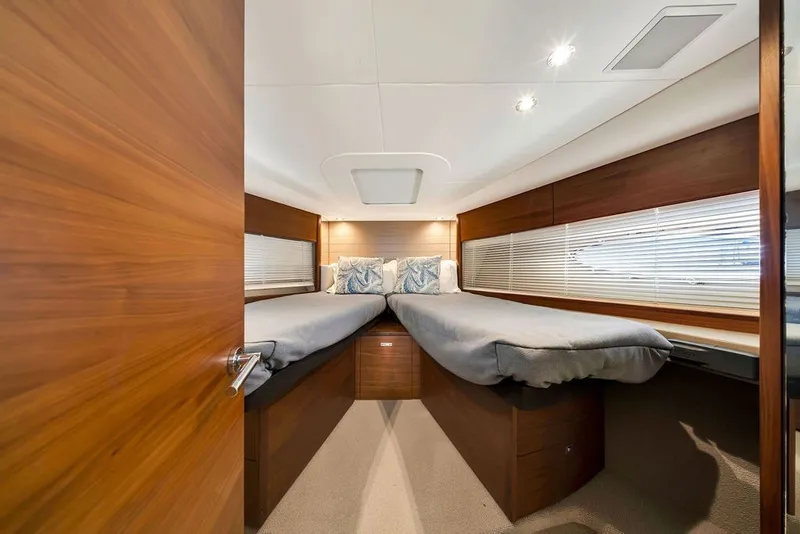 Slide: The Image of Luxurious 2015 Princess V48 yacht cabin with twin beds and elegant wood finish. - 49
