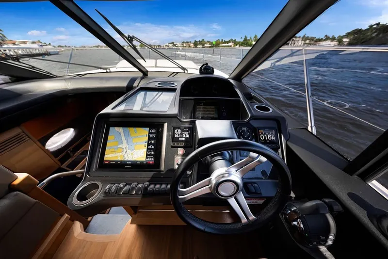 Slide: The Image of Helm of 2015 Princess V48 yacht with navigation screens and steering wheel, cruising on open water. - 29