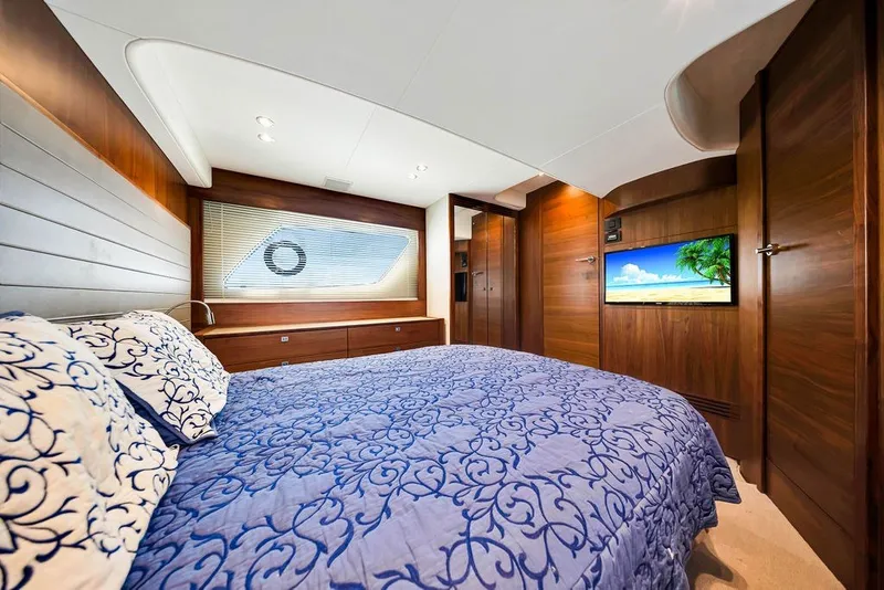 Slide: The Image of Luxurious 2015 Princess V48 yacht bedroom with elegant wood paneling and a cozy bed. - 43