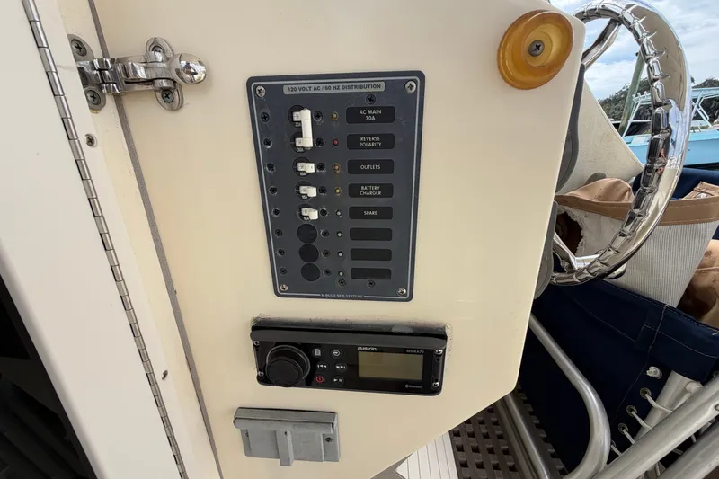 Slide: The Image of Control panel on a 2017 Eastern Boats Seaway Offshore, featuring switches and a radio unit. - 15