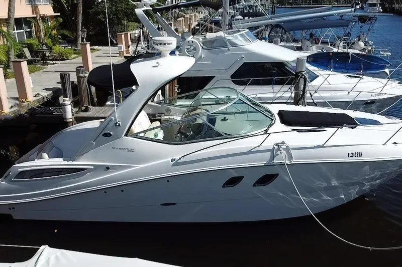 Slide: The Image of 2012 Sea Ray 330 Sundancer docked at marina, sleek white design, sunny day. - 5