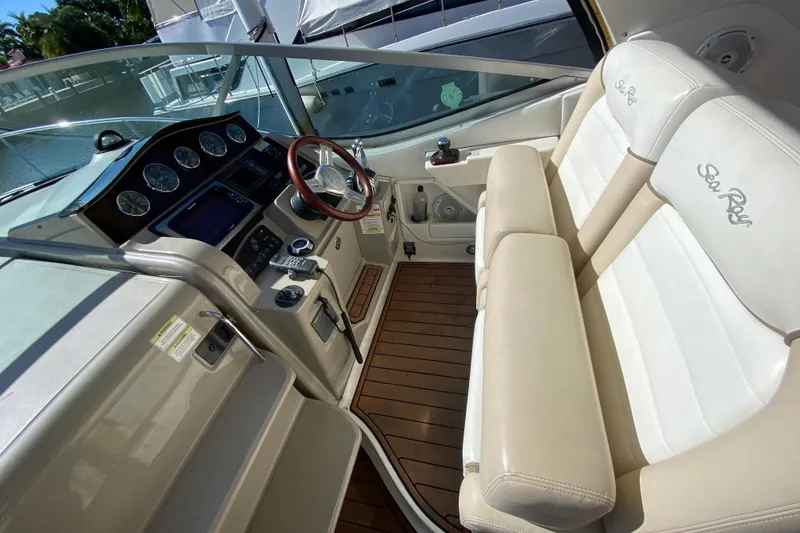 Slide: The Image of 2012 Sea Ray 330 Sundancer cockpit with leather seats and modern dashboard controls. - 22