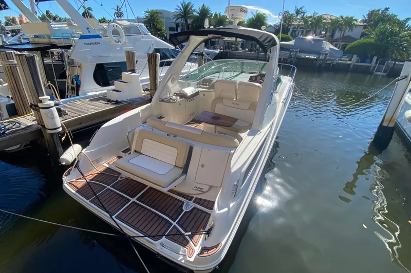 Slide: The Image of 2012 Sea Ray 330 Sundancer docked, featuring spacious deck and luxurious seating. - 18