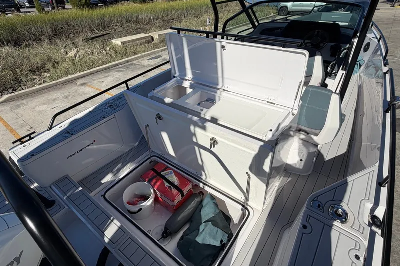 Slide: The Image of 2023 Axopar 28 T-Top boat interior with open storage compartments and seating. - 31