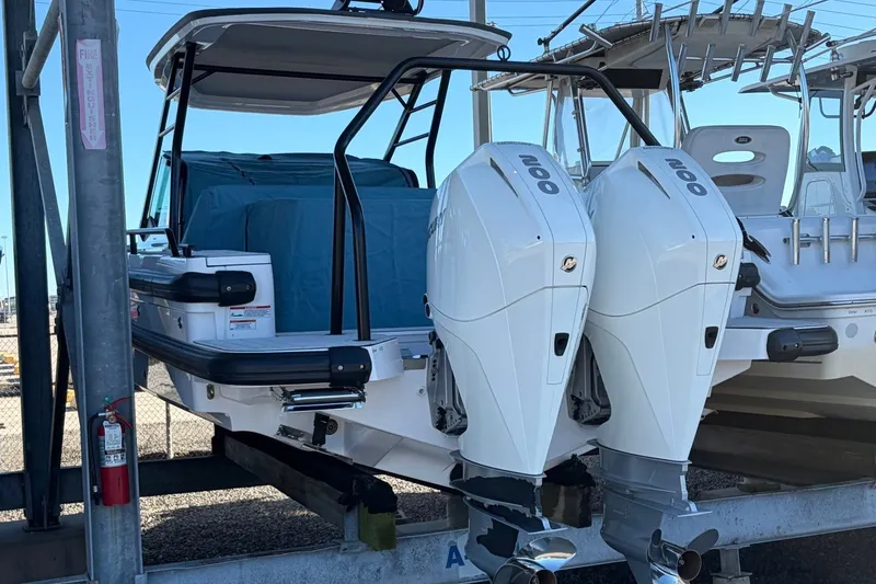 Slide: The Image of 2023 Axopar 28 T-Top boat with dual outboard engines on a trailer. - 35