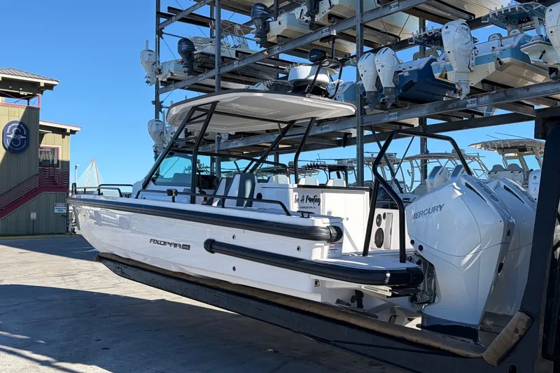 Slide: The Image of 2023 Axopar 28 T-Top boat with Mercury engines in a marina storage facility. - 4