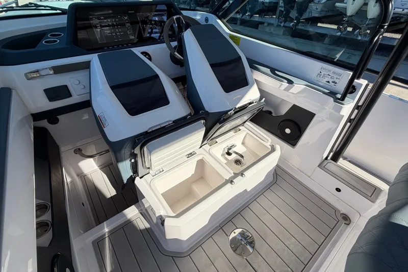Slide: The Image of 2023 Axopar 28 T-Top boat interior with open storage and sleek dashboard design. - 27