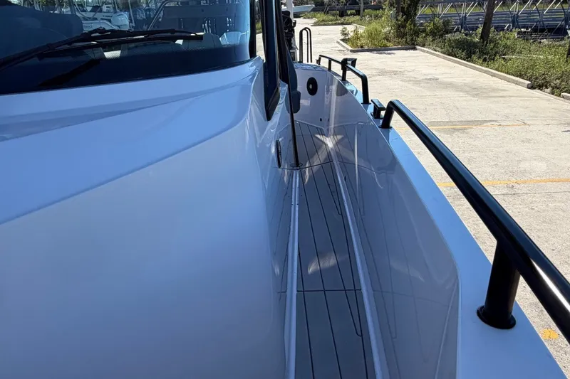Slide: The Image of 2023 Axopar 28 T-Top boat side view with sleek design and railing. - 17
