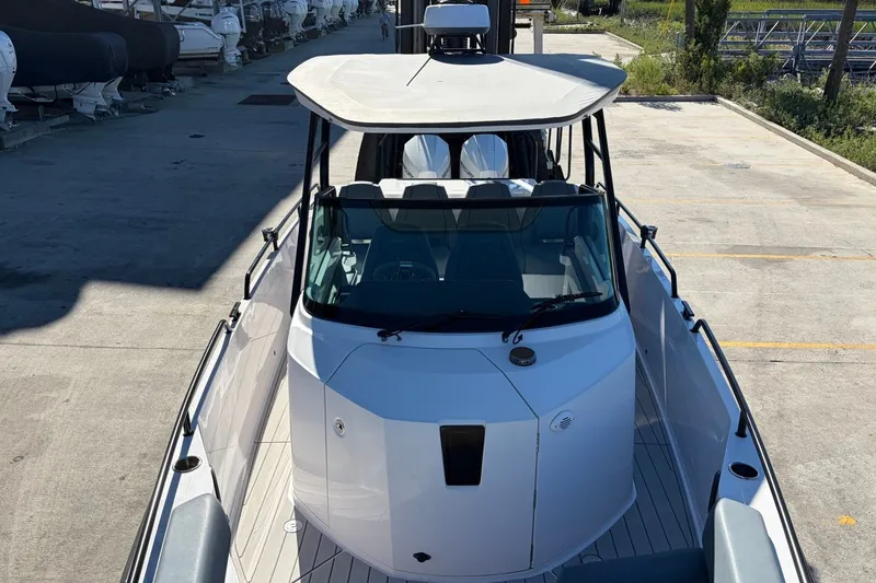 Slide: The Image of 2023 Axopar 28 T-Top boat docked, showcasing sleek design and modern features. - 12