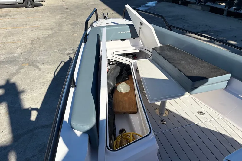 Slide: The Image of 2023 Axopar 28 T-Top boat interior with seating, storage, and table on deck. - 11