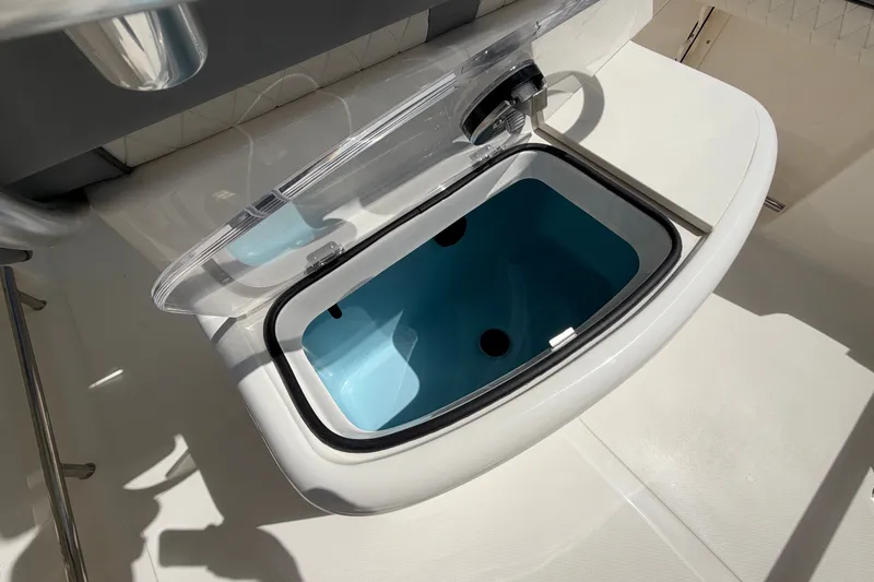 Slide: The Image of Livewell compartment on 2027 Pioneer 202 Sportfish boat, open with blue interior. - 15