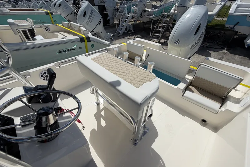 Slide: The Image of 2027 Bulls Bay 2200 XS boat interior with steering wheel, seating, and Suzuki outboard motor. - 15