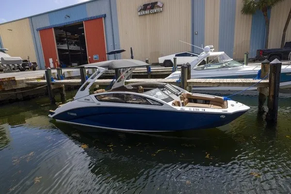 Slide: The Image of A blue and white 2024 Yamaha 275SE boat docked at a marina center. - 20