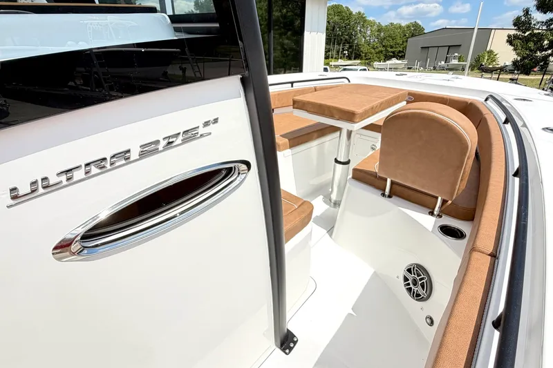 Slide: The Image of 2027 Sea Hunt Ultra 275SE boat interior with tan seating and table, showcasing luxury design. - 21