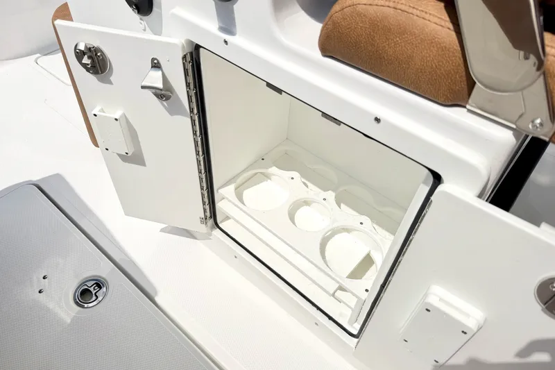 Slide: The Image of Open storage compartment on 2027 Sea Hunt Ultra 275SE boat, featuring cup holders. - 20