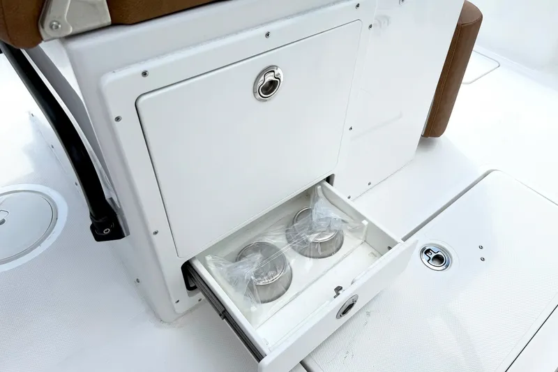Slide: The Image of Storage compartment with cup holders on a 2027 Sea Hunt Ultra 275SE boat. - 17