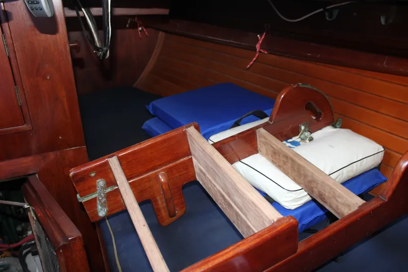 Slide: The Image of Interior of 1981 Cape George 36 Cutter with wooden storage and blue cushions. - 26